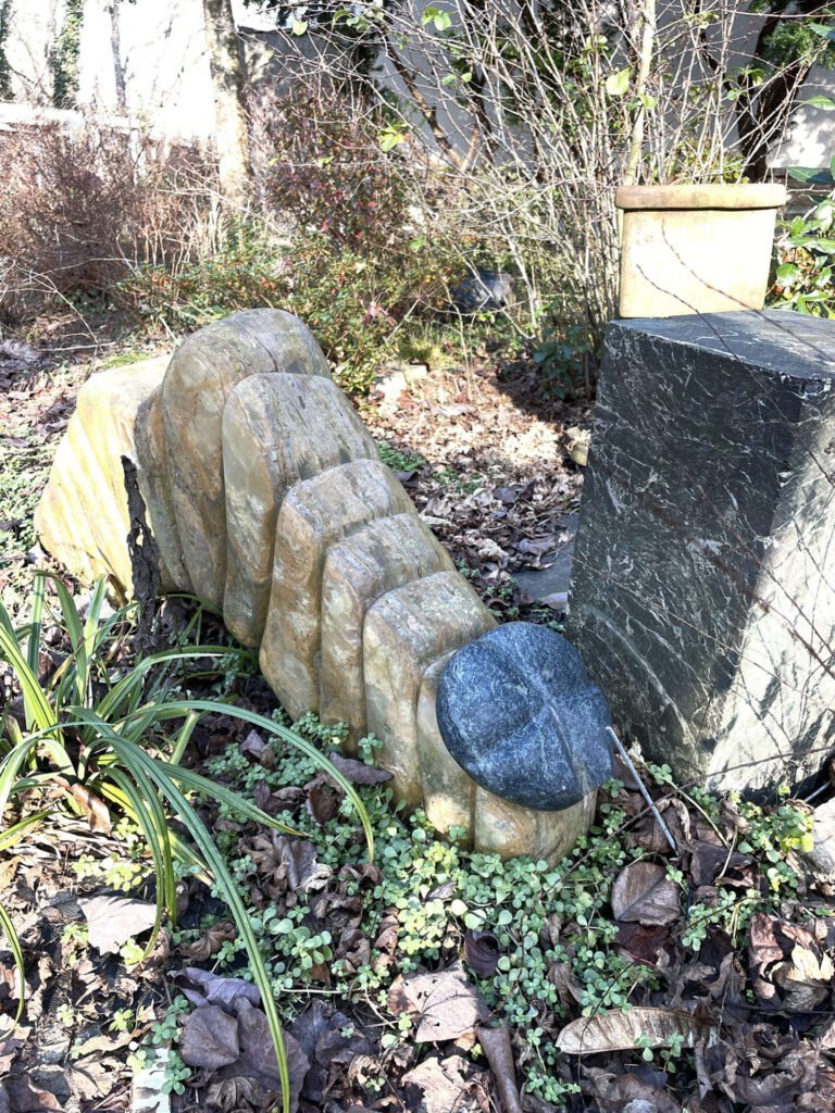 Munch, a marble caterpillar sculpture by Bruce Bennett in the Spring Creek garden.