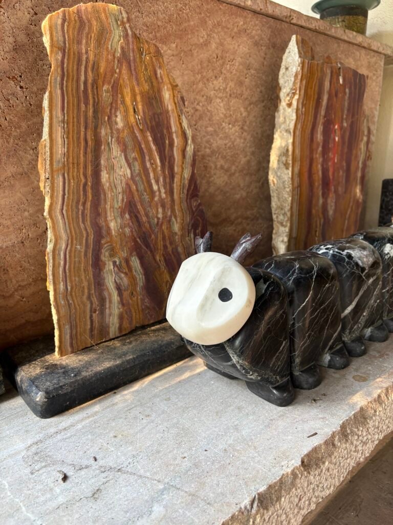 Marcy Caterpillar sculpture by Bruce Bennett displayed with onyx slabs