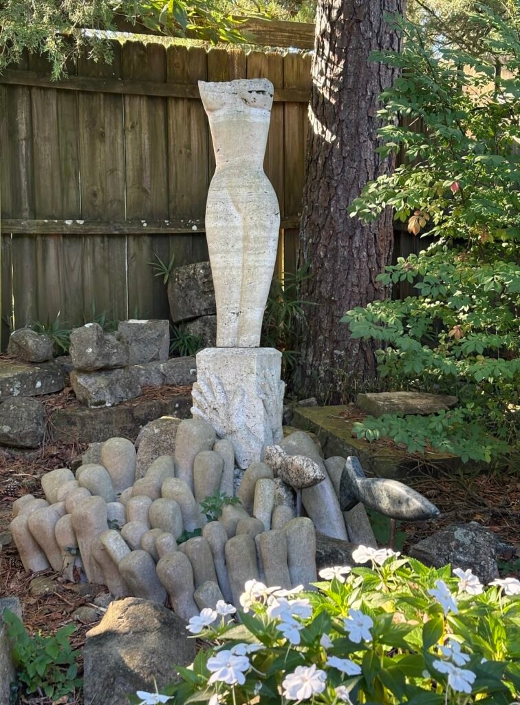 Bruce Bennett’s Athena torso sculpture on a stone pedestal with reaching hands, carved sea anemones, and stone fish at Spring Creek.