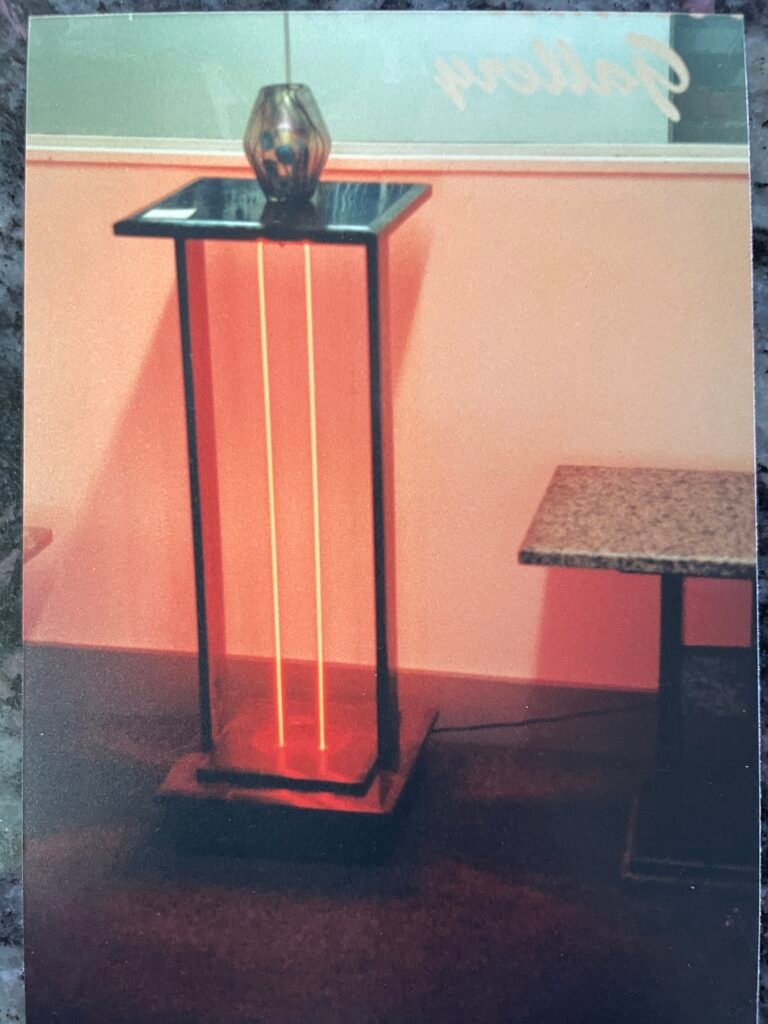 Stone and metal pedestal by Bruce Bennett with illuminated neon elements.