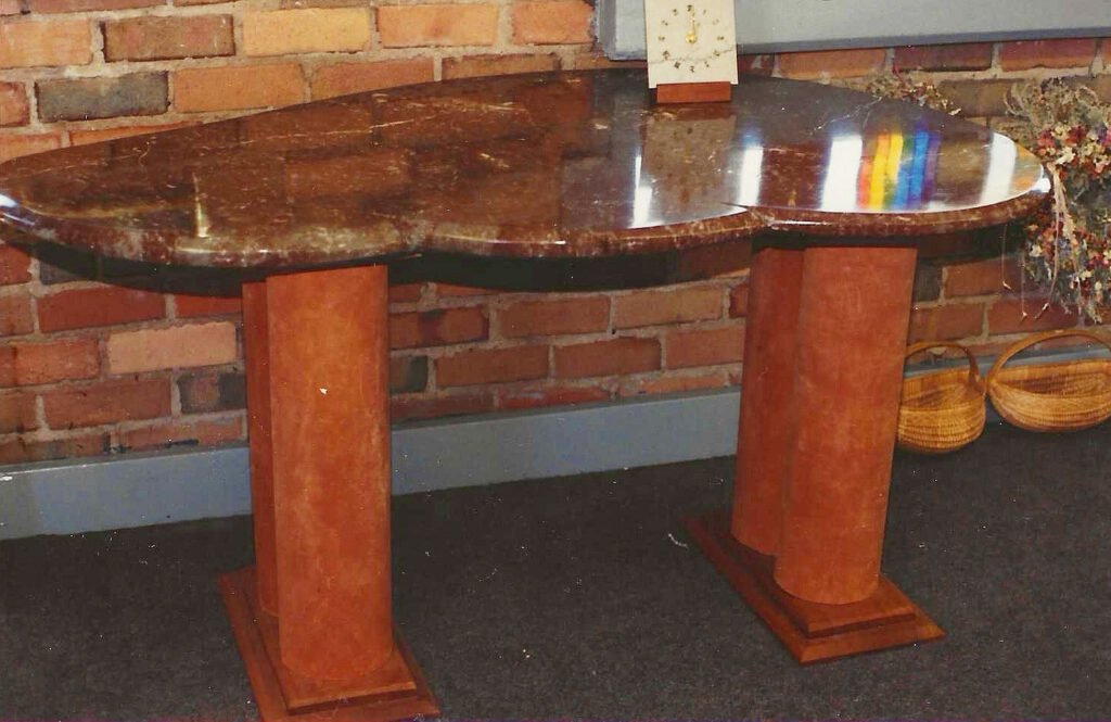 Bruce Bennett console table with a polished biomorphic stone top and paired wood pedestal bases.