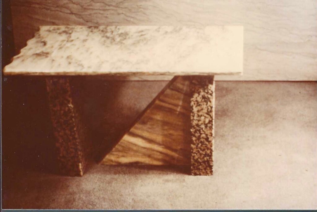 Bruce Bennett console table featuring a light stone top with a geometric mixed-material base of wood and rough-finished stone.