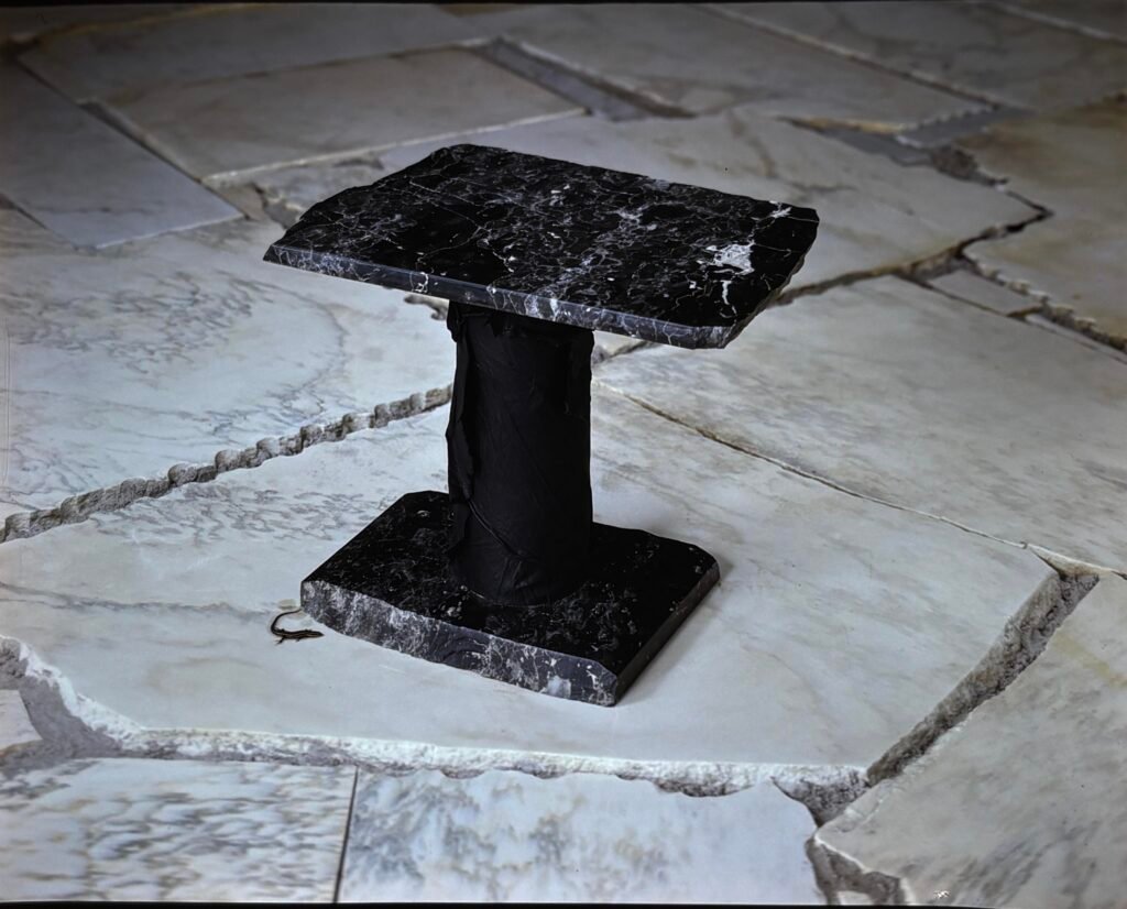 Bruce Bennett pedestal table in Via Lattea granite with polished top and base and a textured central support.
