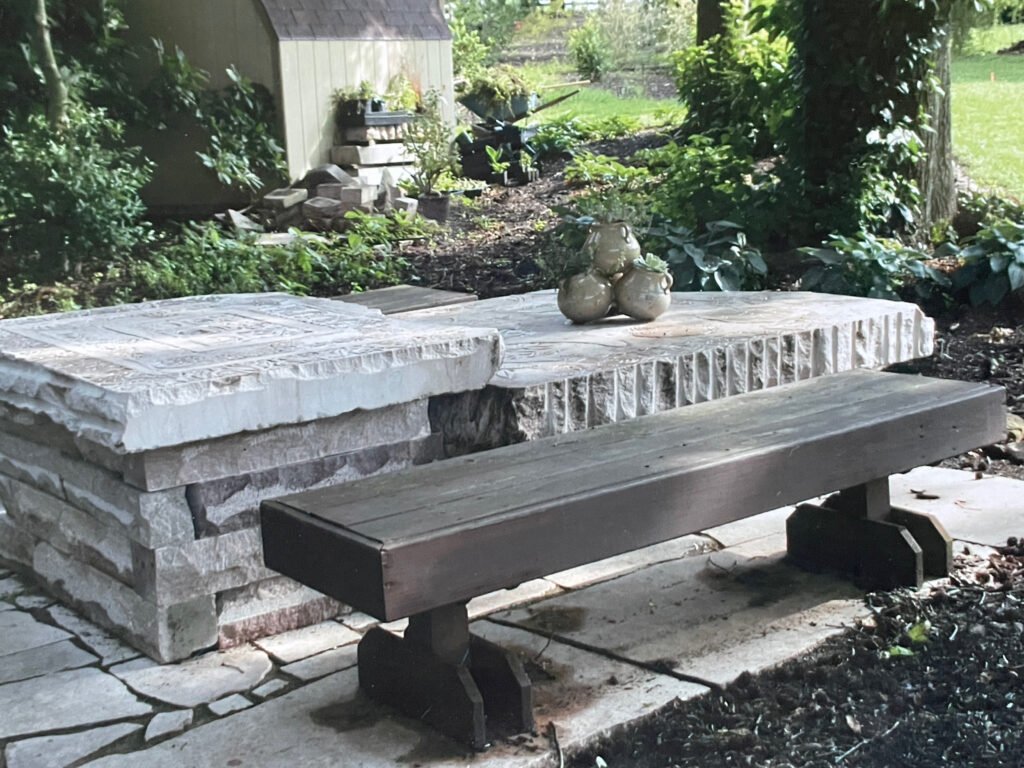 Bruce Bennett outdoor Tennessee limestone table featuring stacked-stone construction, carved tabletops, and textured hand-worked edges.