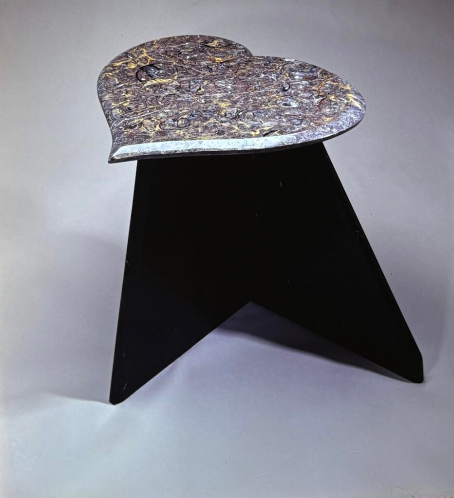 Bruce Bennett table with a heart-shaped Cosmos granite top and dramatic black geometric base.