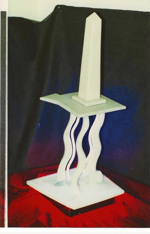 Bruce Bennett’s Postmodern/Memphis-style table, featuring a dramatic, playful undulating base, accompanied by one of Bennett’s obelisks.