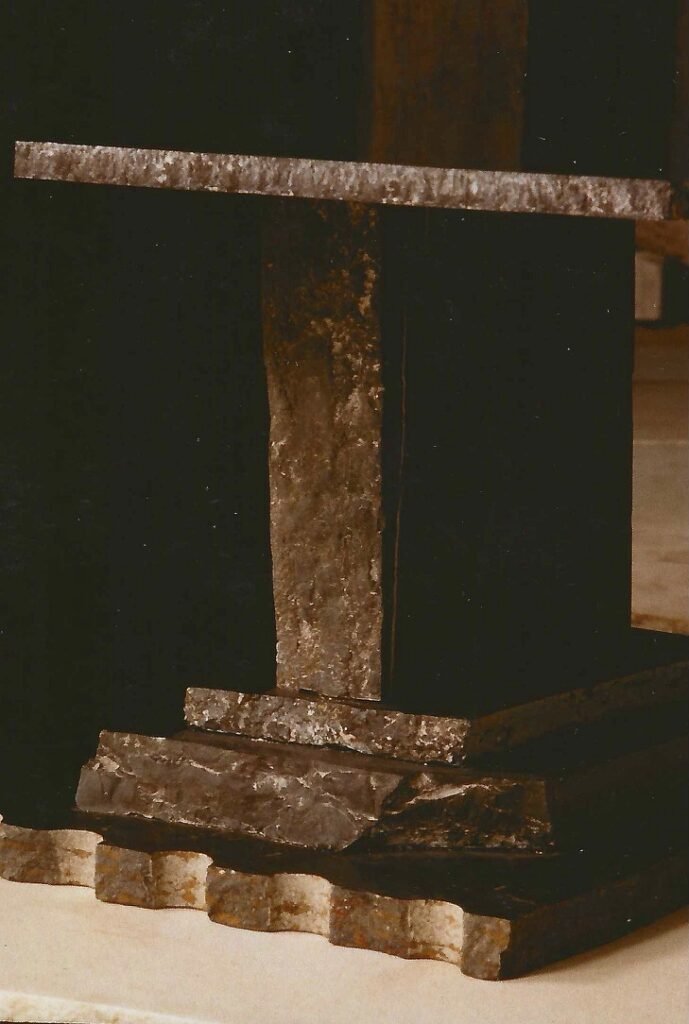 Artist detail showing polished surfaces, natural stone edges, and layered construction in a Bruce Bennett sculptural table.