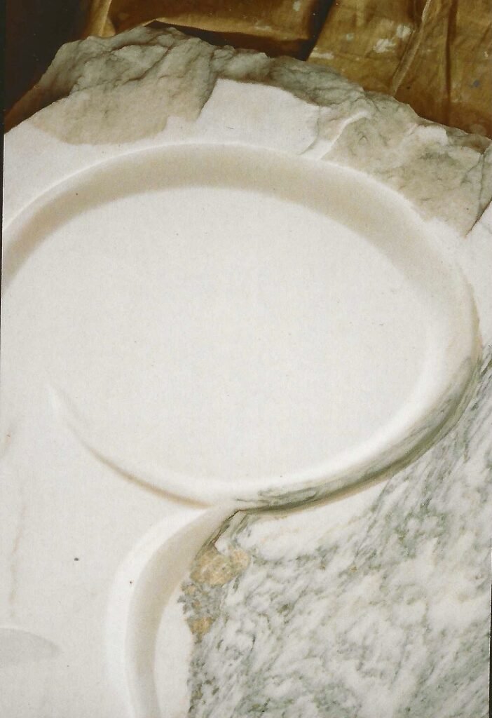 Bruce Bennett sculptural marble table with carved recessed bowls and a natural-edge top.