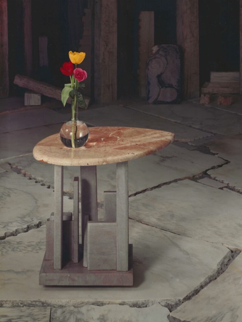 Bruce Bennett table with asymmetrical Rosso marble top and sculptural limestone base.