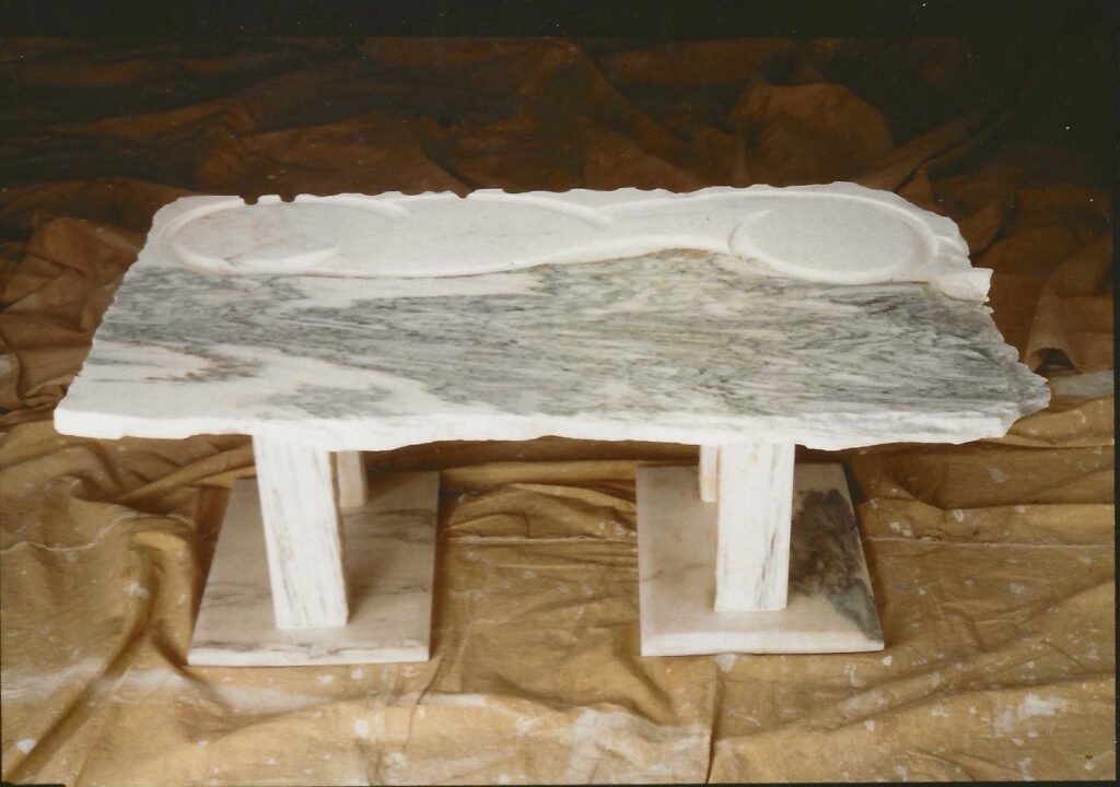 Bruce Bennett sculptural table in Fantasy Brown marble with an irregular carved top.